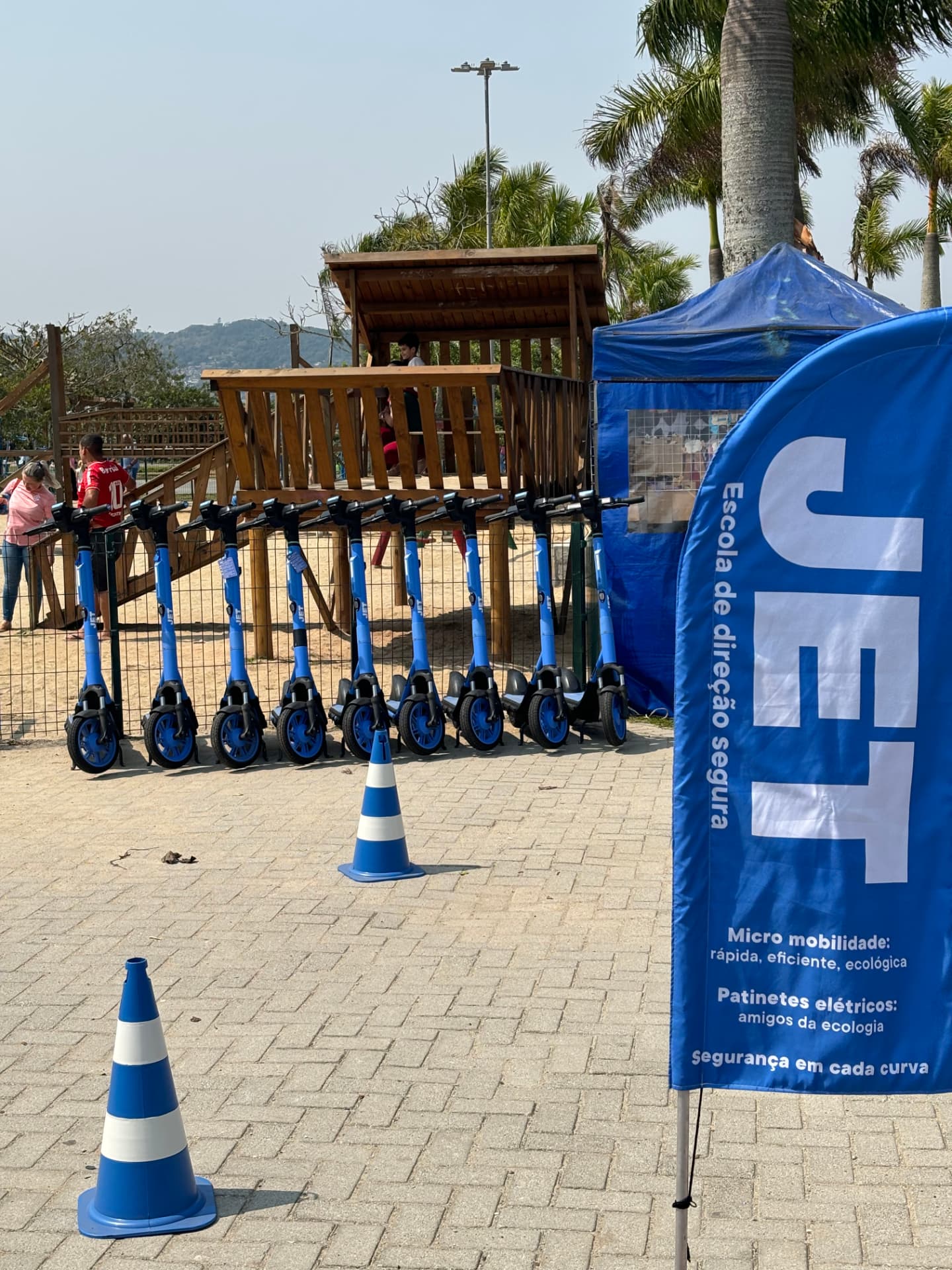Patinetes elétricos JET posicionados em um campus com estrutura de atendimento